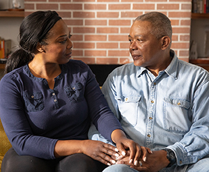 Woman and man sitting on couch, talking.