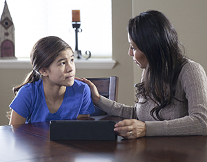 Mujer y niña que miran una tableta electrónica.